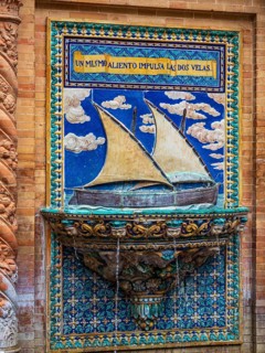 Botanic garden at the plaza espana, fountain with decoration showing sailing ship, Seville,
