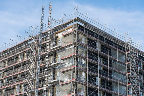 Symbolic image, residential construction, new building, corner building with extensive scaffolding,