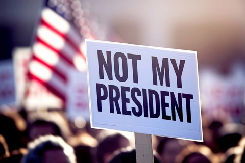 Close up of a protest sign with text 'Not my president with crowd in blurry background. Generative