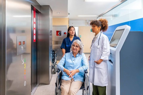 Medical professionals providing care and support to a senior woman in a wheelchair, navigating a