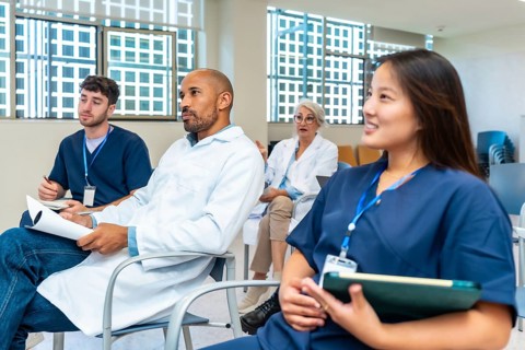 Doctors and nurses listening to presentation during medical conference in hospital meeting room
