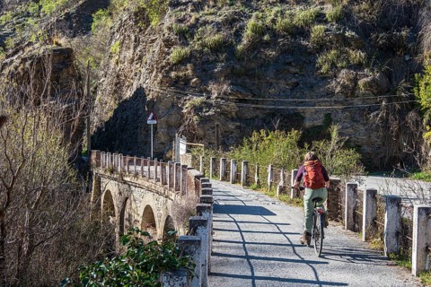 Cyclist on the Tranvía de Sierra Nevada, former railroad track, leading to the trail Vereda de la