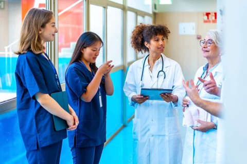 Doctors and nurses having a discussion about a patient's medical records in a hospital hallway