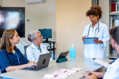 Doctors and nurses participating in a medical briefing, analyzing patient data and treatment plans