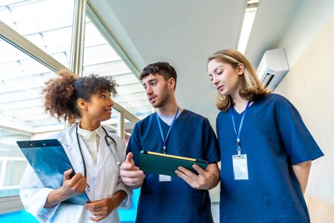 Doctors and nurses examining medical records and x rays, collaborating on patient care in a