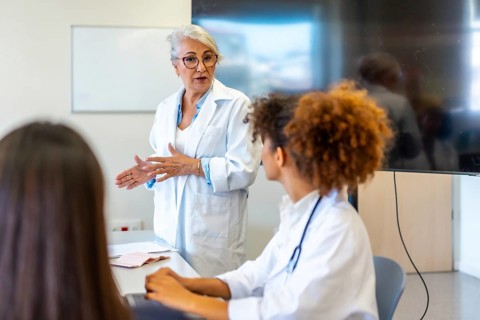 Experienced doctor conducting a training session for young medical professionals, fostering