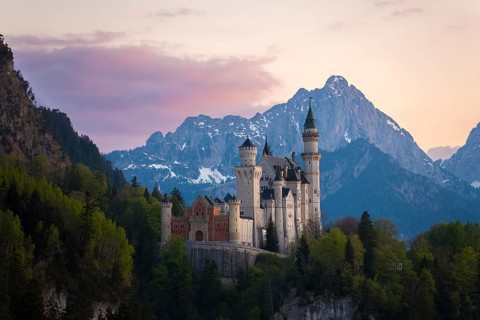 Fairytale Neuschwanstein Castle framed by the Alps after sunset, Schwangau near Füssen, Ostallgäu