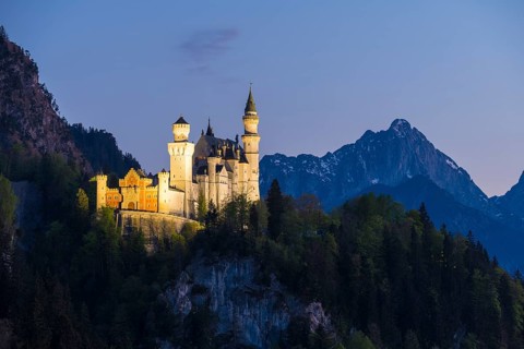 Fairytale castle in front of a tranquil and mysterious mountain landscape, Neuschwanstein,