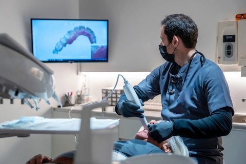 Dentist using an intraoral scanner for 3d scanning of teeth, creating precise digital models for