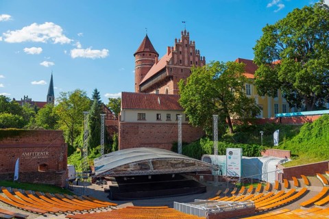 Medieval castle with open-air amphitheatre and surrounding trees, castle and amphitheatre, Olsztyn,