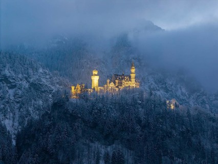 Fairytale castle surrounded by fog in a snow-covered mountain landscape, Neuschwanstein, Schwangau,