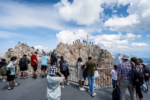 Tourists on the viewing platform at the summit of the Zugspitze, overtourism, mountain station of