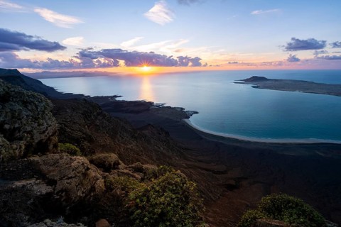 View from steep cliffs to sea and coast with sun stars, Mirador del Porrito viewpoint at sunset,