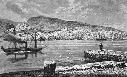 A smoking steamship passes the town of Ermoupoli on the Cyclades island of Syros or Siros, sailing