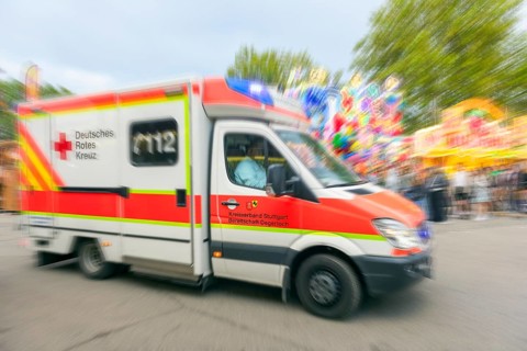A German Red Cross ambulance drives quickly to an operation at the Cannstadter Volksfest, K