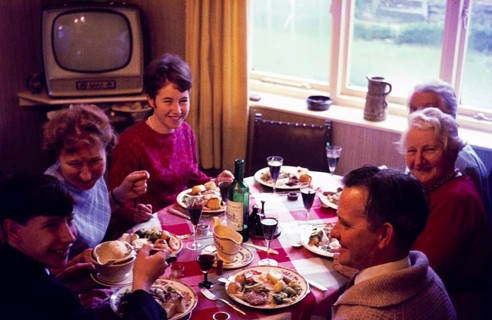 Traditional family Christmas meal all sitting around table eating and drinking, c 1960, England, UK