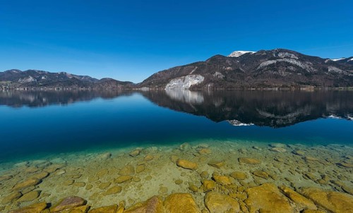 Lake Wolfgang with a reflection of the surrounding mountains, near St. Gilgen, Salzkammergut,