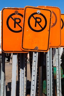 Close-up of fluorescent orange and black No Parking mobile street signs, Quebec, Canada