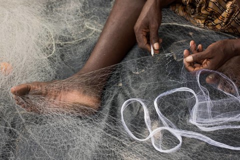 Fisherman mending a fishing net, Kerala, India