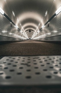 Long, illuminated tunnel with tiled walls from the ground perspective, old Elbe tunnel, Hamburg,
