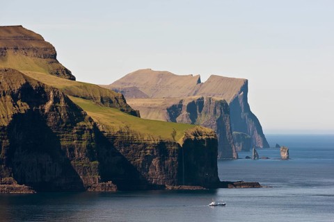 Fishing boat in front of Eysturoy, the basalt columns Risin and Kellingin at the back, Kalsoy,
