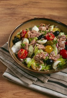 Salad with canned tuna, vegetable salad with quail eggs, lettuce, red onion, cherry tomatoes,