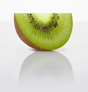 A kiwi slice, kiwi, kiwi fruit, Chinese gooseberry (Actinidia deliciosa) in front of a white