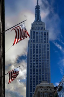 Waving US flag with Empire State Building, New York City, USA