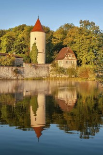 Digester's tower with park keeper's house on the town wall in the morning light, reflection in the