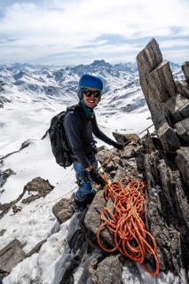 Mountaineer belaying with rope, climbing up a steep snow slope, belaying with rope, ascent to the