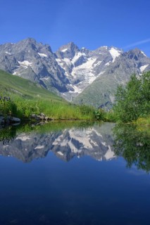 Pointe Piaget and La Meije reflected in the pond of the botanical garden Jardin du Lautaret,