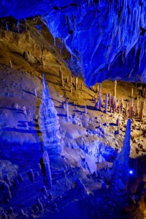 Blue illuminated stalagmites and stalactites in a cave, Devil's Cave Pottenstein, Franconian