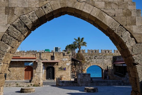 Arched wall overlooking the sea and historic buildings, Rhodes Old Town, Rhodes, Dodecanese, Greek