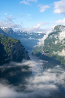 View over the Geirangerfjord, atmospheric clouds over the fjord in the morning light, Ørnesvingen