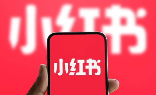 RedNote (Xiaohongshu) logo is displayed on smartphone