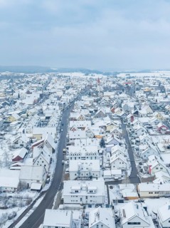 Small settlement under snow cover with straight main road, Deckenpfronn, Böblingen district,