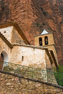 Old church with bell tower, embedded in a mountainous landscape with stone walls, Las Peñas de