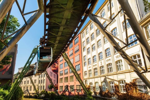 A suspension railway runs between old industrial buildings near the Kluse stop, Wuppertal, Germany