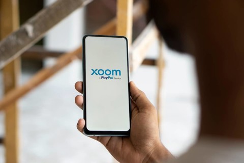 xoom logo is displayed on smartphone. Xoom Corporation is an electronic funds transfer and