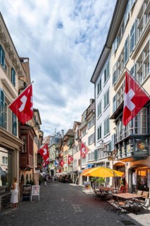 Augustinergasse with Swiss flags, alley with historic houses, Old Town, Zurich, Switzerland