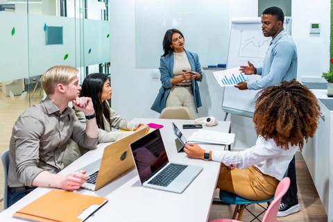 Diverse marketing team analyzing growth charts during a productive meeting in a modern coworking