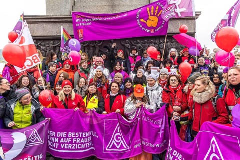 DGB woman proclaim international solidarity at a trade union rally. The trade unionists wear purple