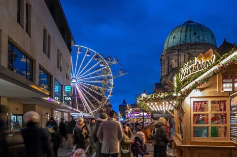 Ferris wheel at the winter village, Christmas market at dusk, St Elisabeth's Church on the right,