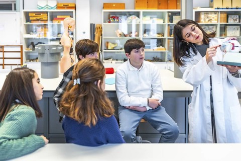 Science teacher engaging high school students with an anatomical model during an interactive