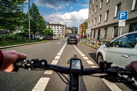 Cycling in the city, city centre road, car blocking cycle lane traffic in both directions, cyclist