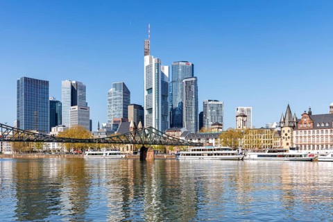 Frankfurt skyline skyscrapers with banks on the river Main with excursion boats and Eiserner Steg