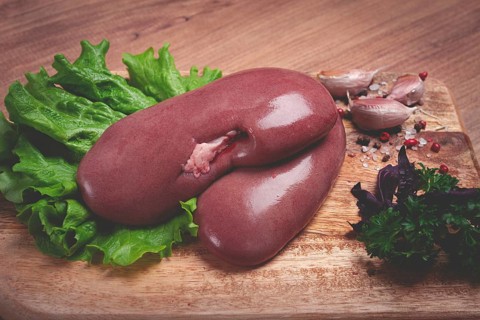 Raw pork kidneys, on a chopping board, close-up, top view, no people
