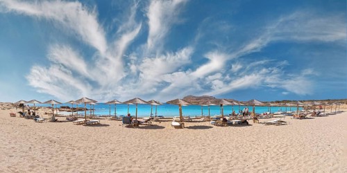 Diakoftis extensive sandy beach with parasols and sun loungers under a clear blue sky, Diakoftis