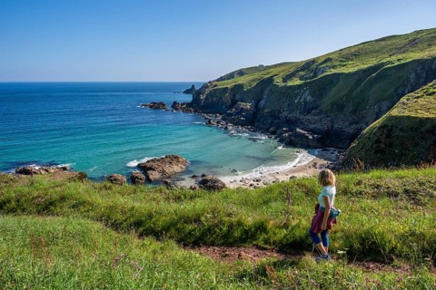 A hiker on a coastal path. View of Rose-an Hale Cove. Between Gurnard's Head and Carnelloe Headland