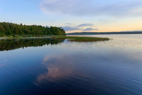 A calm lake in the morning with peaceful natural scenery and reflective clouds, Lake Mahinapua,